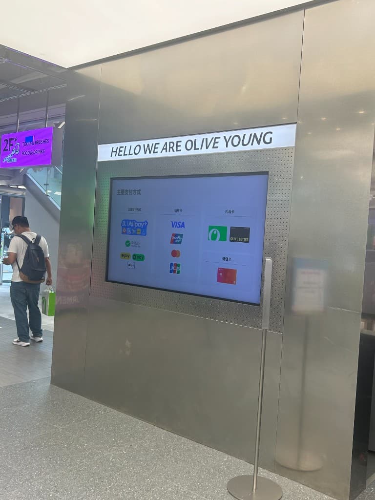 Payment method screen inside Olive Young Hongdae Town showing Alipay, WeChat Pay, Apple Pay, Visa, UnionPay, Mastercard, and JCB logos